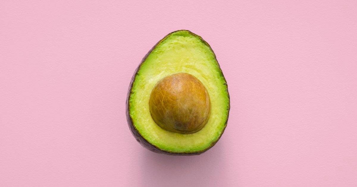 Fresh avocado halves with green flesh and a seed