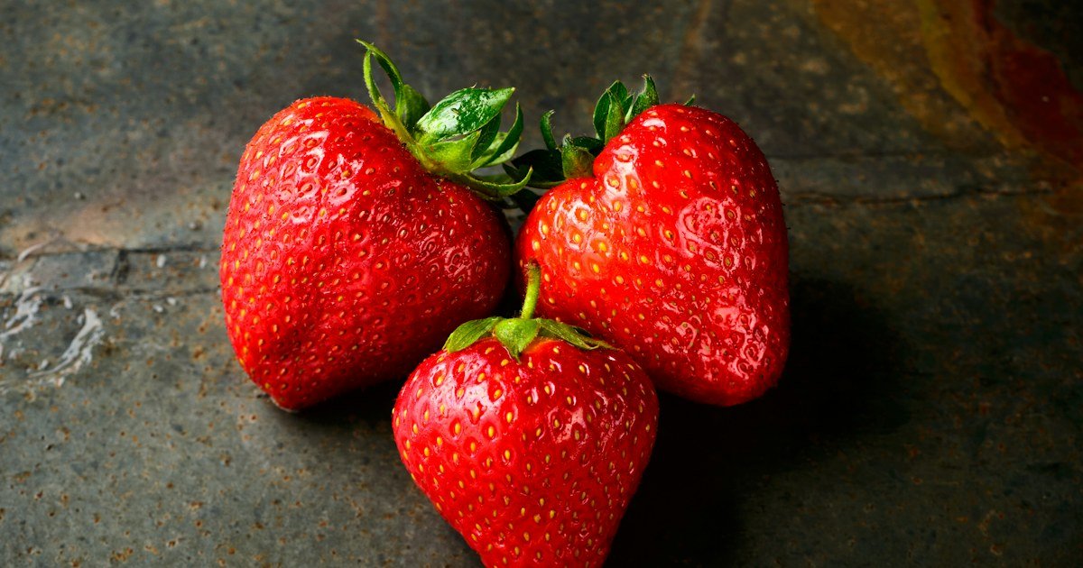 Strawberries ripening among green leaves in a container garden